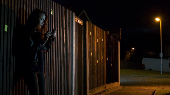 The orange backlight on Faith (Haruka Abe) and the fence, although apparently from the streetlamp in the background, is actually from an Arrilite 650 out of frame right, gelled with Urban Sodium. A daylight-balanced LED panel, also out of frame right but closer to camera, keys Faith. A second panel hidden behind the end of the fence lights the van and the rest of the deep background.